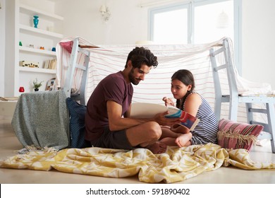 Father And Daughter Playing Indoors In Home Made Den