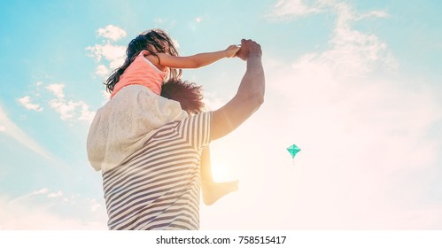 Father with daughter playing with kite and having fun on the beach - Dad enjoying time with his kid outdoor - Family relationship and love concept - Focus child body - Sunset colors tones filter - Powered by Shutterstock