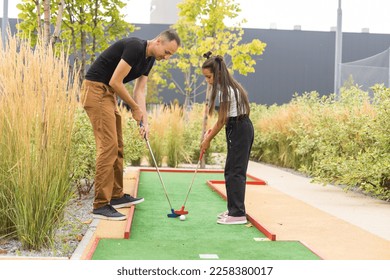 father and daughter playing mini golf - Powered by Shutterstock