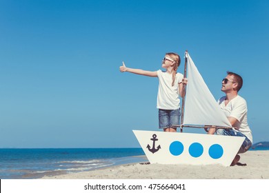 Father and daughter playing on the beach at the day time. People having fun on nature. Concept of friendly family. - Powered by Shutterstock