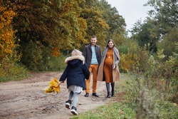 Father Daughter And Pregnant Mother Walking By Autumn Park Young Happy Family