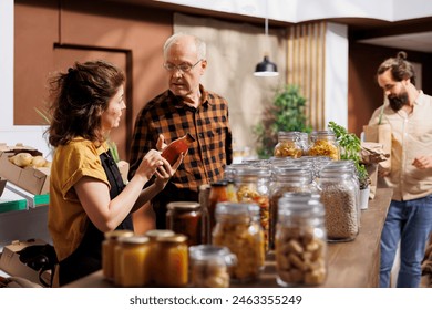 Father and daughter shopping in zero waste store looking for locally sourced bulk products. Family members purchasing pantry staples from local neighborhood shop with zero carbon dioxide emissions - Powered by Shutterstock