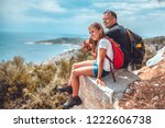 Father and daughter sitting on cliff