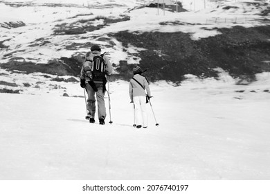 Father And Daughter With Ski Poles On Snowy Slope In Little Snow Winter. Caucasus Mountains, Georgia, Region Gudauri. Black And White Toned Image.