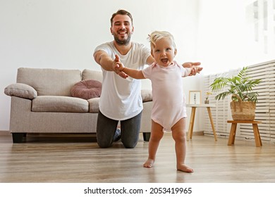 Father And Daughter Spending Quality Time Together.A Child Learning To Walk. Bearded Man With His Adorable Blonde Toddler. Close Up, Copy Space For Text, Background.