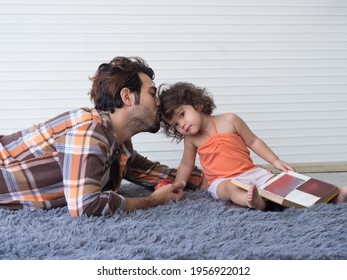 Father And Daughter Spending Time Together. Dad Kisses Cute Little Toddler Girl On The Hair With Love.