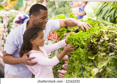 Father And Daughter In Supermarket Produce Section