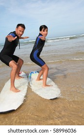 Father And Daughter Surfing In The Ocean