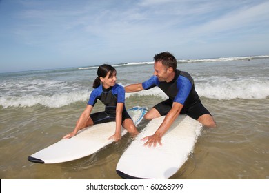 Father And Daughter Surfing In The Ocean