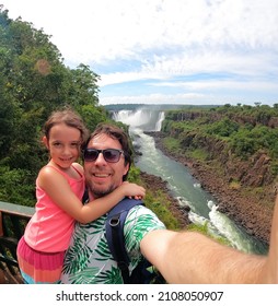 Father And Daughter Taking A Selfie At `Iguaçu Falls` On The Brazilian Border