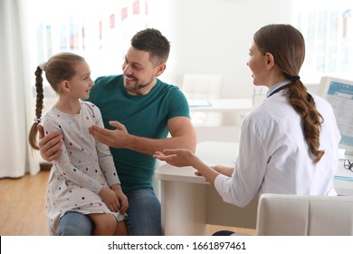 Father and daughter visiting pediatrician. Doctor working with little patient in hospital - Powered by Shutterstock