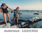 Father and daughter walking along rocky beach and having adventure by the sea