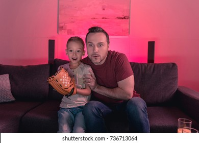 Father And Daughter Watching A Baseball Game At Home With Surprised View