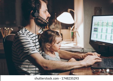 Father and daughter are working on a laptop. businessman working from home and watching the child. A young man works on a computer. Launch. Freelancer concept. Family on quarantine
