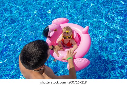 Father With Daughters In The Pool. Selective Focus. Child.