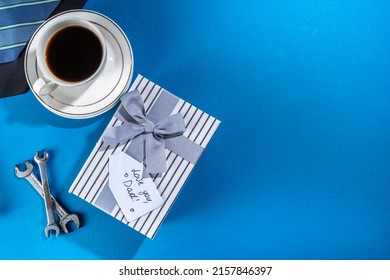 Father Day Greeting Card Background. Fathers Day Concept With Gift Box, Tools And Ties, Coffee Cup, Gift Tag  Love You Dad, On Brightblue Background Top View Copy Space