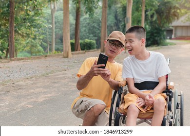 Father and Disabled child on wheelchair in the city park, They have fun with selfie by smart phone, Life in the education age of special children,Happy disability kid travel in family holiday concept.