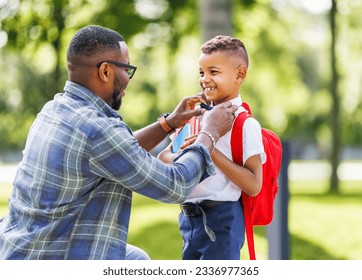 Father escorts happy first-grader boy to school, straightens his bow tie before classes
 - Powered by Shutterstock