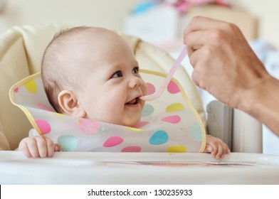 Father Feeding Baby With Spoon