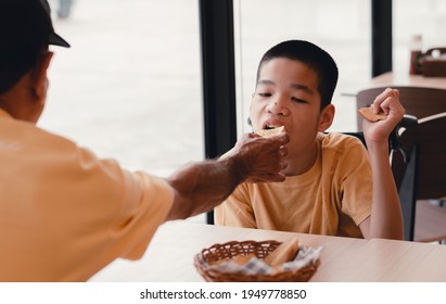 Father Feeding Food To Disabled Child On The Wheelchair In Home Or Restaurant,He Practiced Eating Food,Special Children's Lifestyle,Lifestyle In The Education Age Of Kids,Happy Disability Kid Concept.