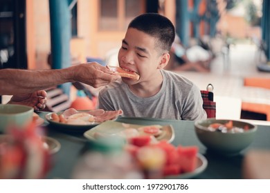 Father Feeding Food To Disabled Child On The Wheelchair In Home Or Restaurant,He Practiced Eating Food,Special Children's Lifestyle,Lifestyle In The Education Age Of Kids,Happy Disability Kid Concept.