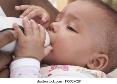 Father Feeding Her 3 Months Old Baby Girl With Formula Powder. 