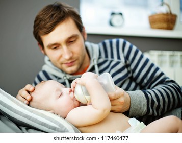 The Father Feeding His Baby At Home