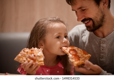 Father Feeding His Cute Daughter With Pizza