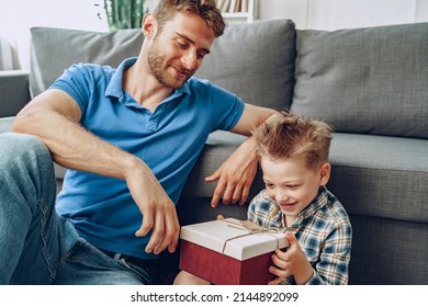 Father gives a present in box to his little son