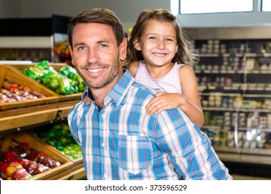 Father Giving Piggy Back To Daughter In Grocery Store