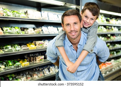 Father Giving Son A Piggy Back In Grocery Store