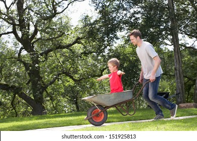 Father Giving Son Ride In Wheelbarrow