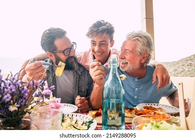 Father grandfather and son eaing together having fun. father's day concept celebration with men family enjoying meal on the table. Cheerful man young adult and mature laughing and having lunch - Shutterstock ID 2149288095