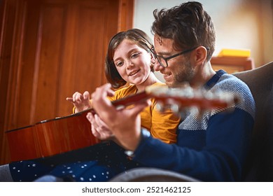 Father, guitar and girl in home for bonding, teaching and development with music, relax and playing. Dad, instrument and daughter in apartment for relationship, learning and hobby with fun lesson - Powered by Shutterstock