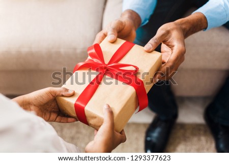 Father hands giving birthday gift to daughter, closeup