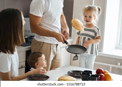 father having fun with pancakes in the kitchen, man boasting about his cooking skills - Powered by Shutterstock