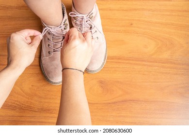 Father Is Helping His Daughter Tie Her Pink Shoelaces