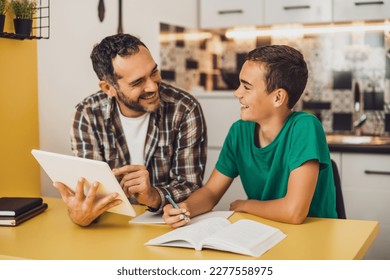 Father is helping his son with learning. They are doing homework together. - Powered by Shutterstock