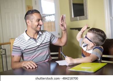 A Father helping son do homework. Parent helps his child