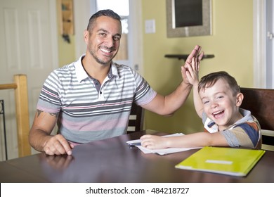 A Father Helping Son Do Homework. Parent Helps His Child