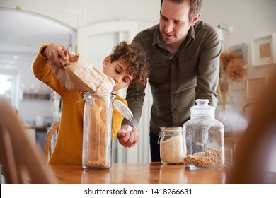 Father Helping Son To Refill Food Containers At Home Using Zero Waste Packaging