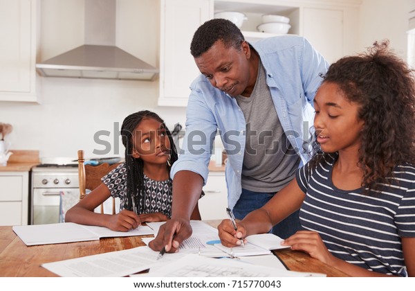 Father Helping Two Daughters Sitting Table Stock Photo 715770043 ...