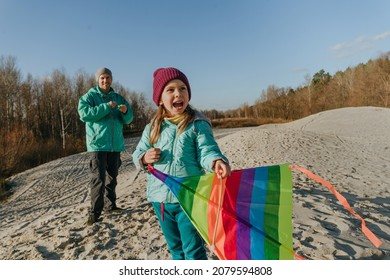 Father with his 5 years old daughter prepairing kite to fly. Happy family activities outdoor. Parenthood concept.
