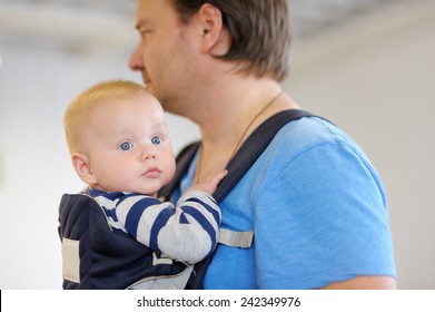 Father And His Baby Boy In A Baby Carrier 