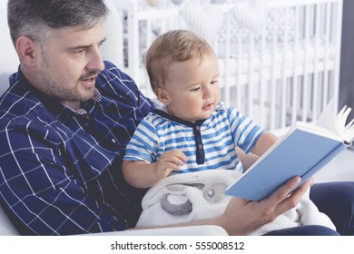 Father with his baby on his laps reading a book