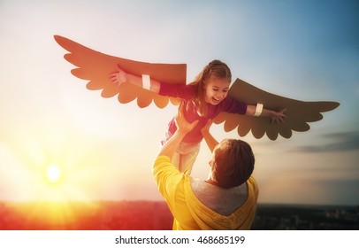 Father and his daughter child playing together. Little girl plays in the bird. Happy loving family having fun.