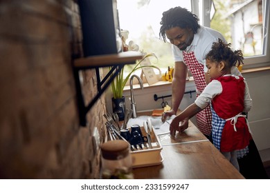  father and his daughter come together to tackle the task of washing dishes. They stand side by side at the sink, their hands immersed in soapy water, as they diligently clean the dishes. - Powered by Shutterstock