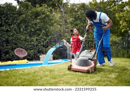  father and his daughter as they engage in a shared activity of lawn care. 