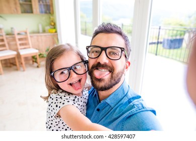 Father with his little daughter sticking tongue out - Powered by Shutterstock