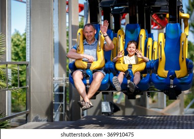 Father And His Little Son Enjoy The Ride At Attraction Park